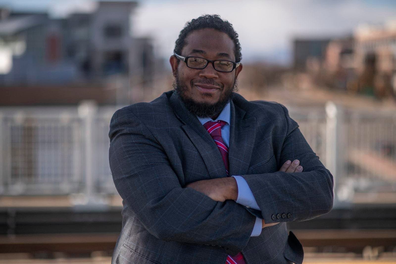 Colorado State Representative Michael Carter wearing a suit outdoors